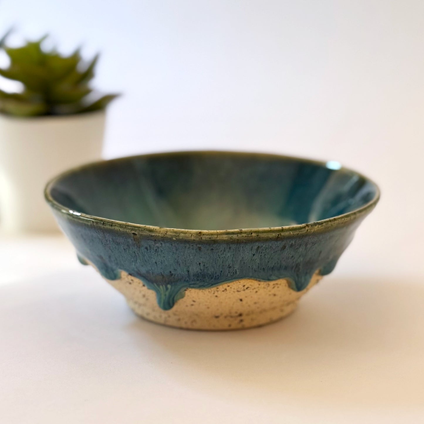 Ceramic bowl with blue glaze on a white surface