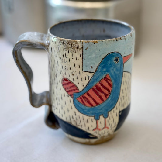 Ceramic mug with a bird design on a white surface