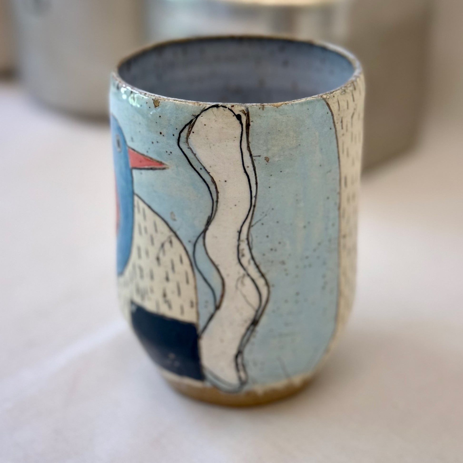 Ceramic cup with abstract design on a light surface