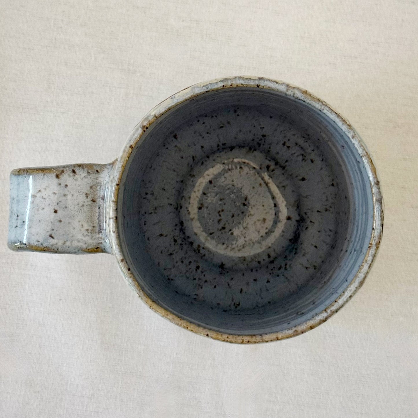 Ceramic mug with speckled design on a light background
