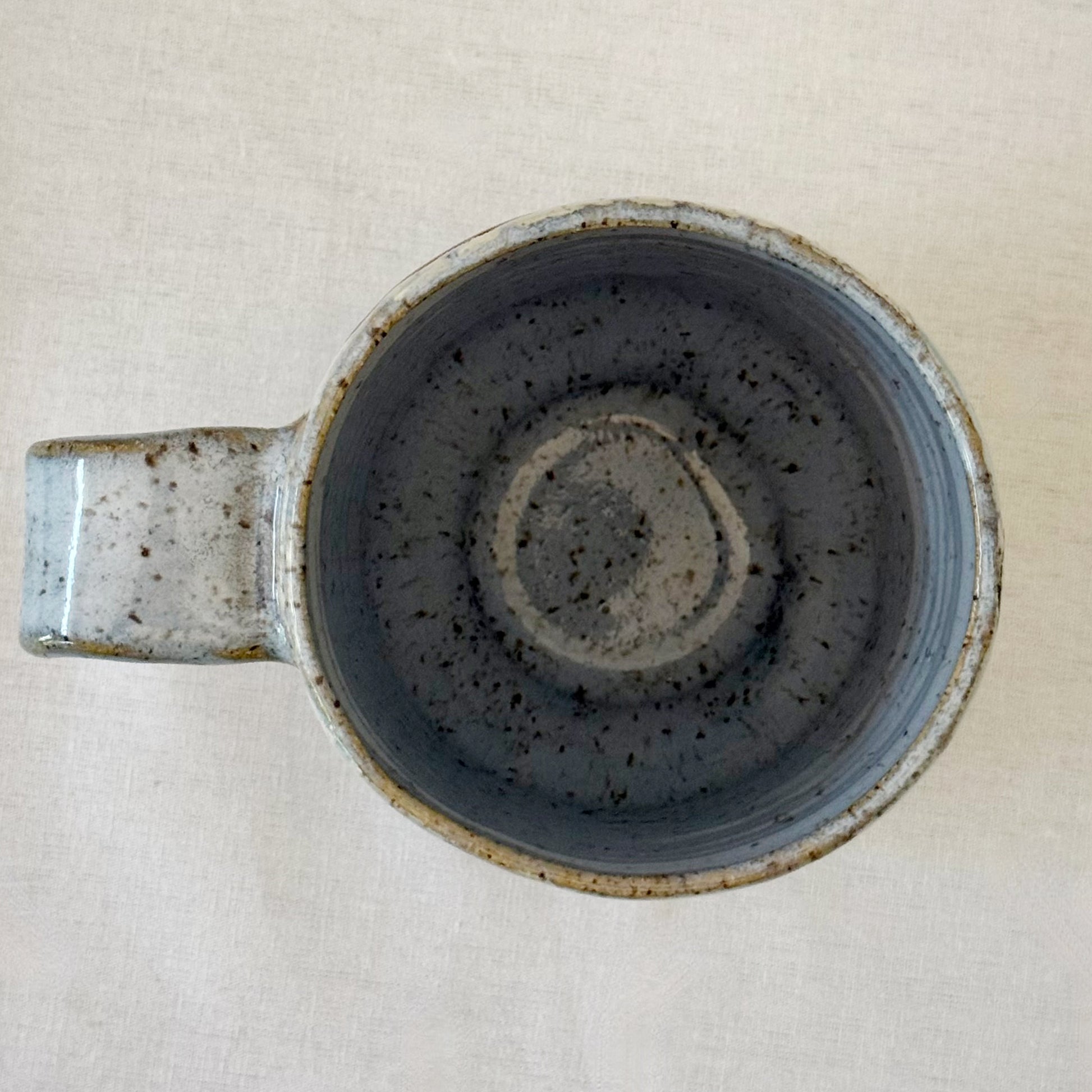 Ceramic mug with speckled design on a light background