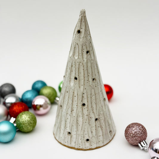 Speckled ceramic Christmas tree with colorful ornaments on a white background