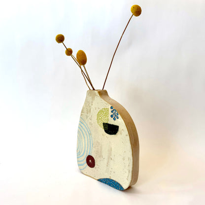 Handmade ceramic vase with a rounded form, featuring two different hand-drawn illustrated designs on opposite sides, photographed on a neutral background.