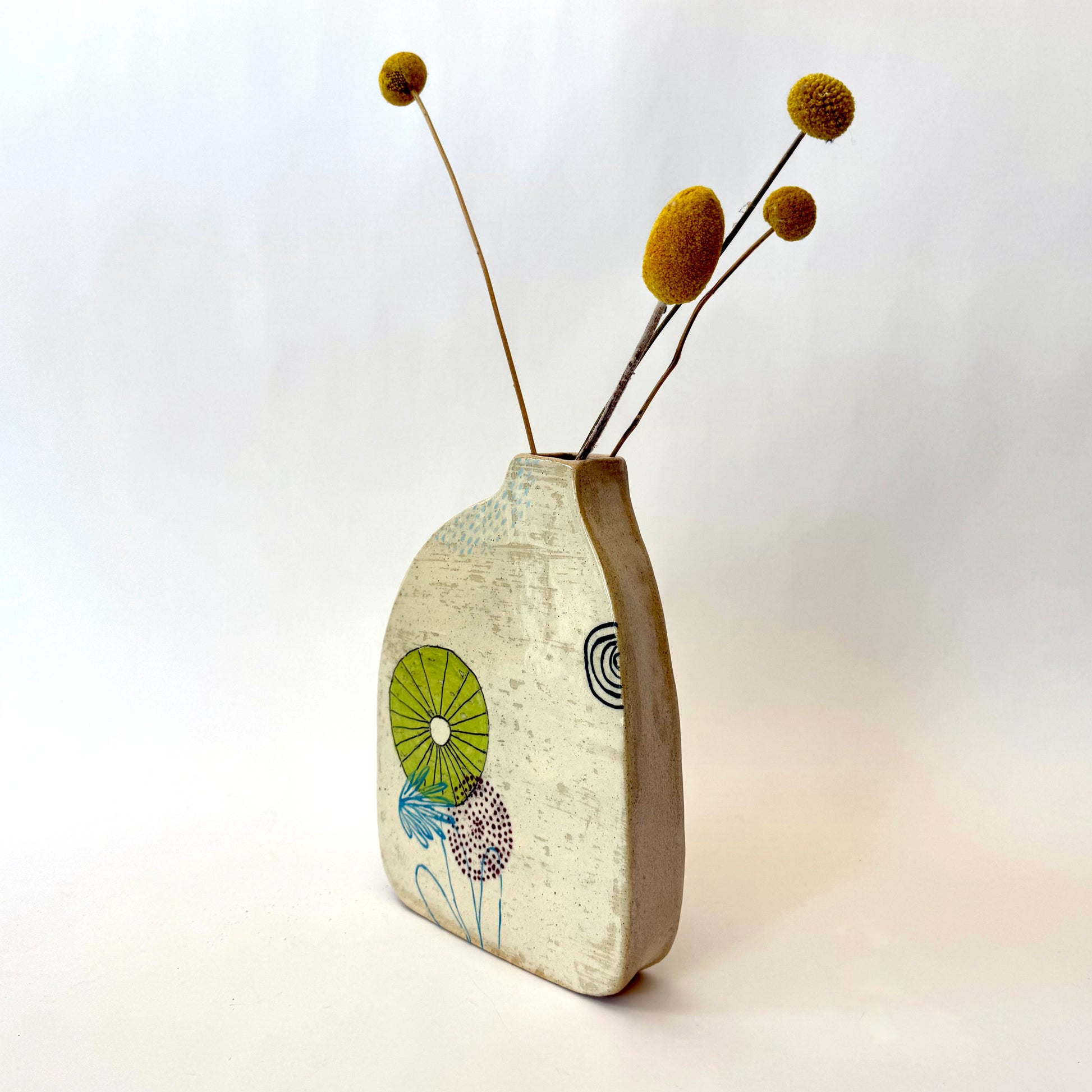 Handmade ceramic vase with a rounded form, featuring two different hand-drawn illustrated designs on opposite sides, photographed on a neutral background.