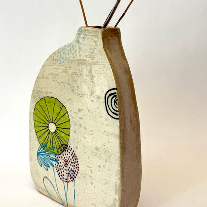 Handmade ceramic vase with a rounded form, featuring two different hand-drawn illustrated designs on opposite sides, photographed on a neutral background.