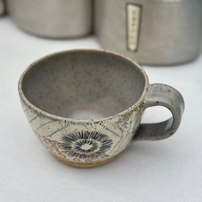 Ceramic mug with decorative patterns on a white surface