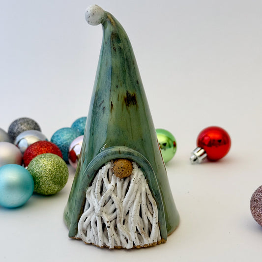 green ceramic gnome with ornaments on white background