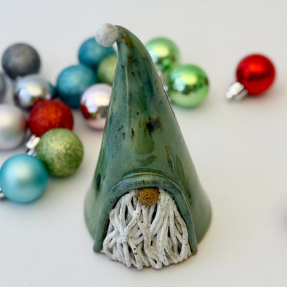 green ceramic gnome with ornaments on white background