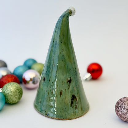 back view of green ceramic gnome with ornaments on white background