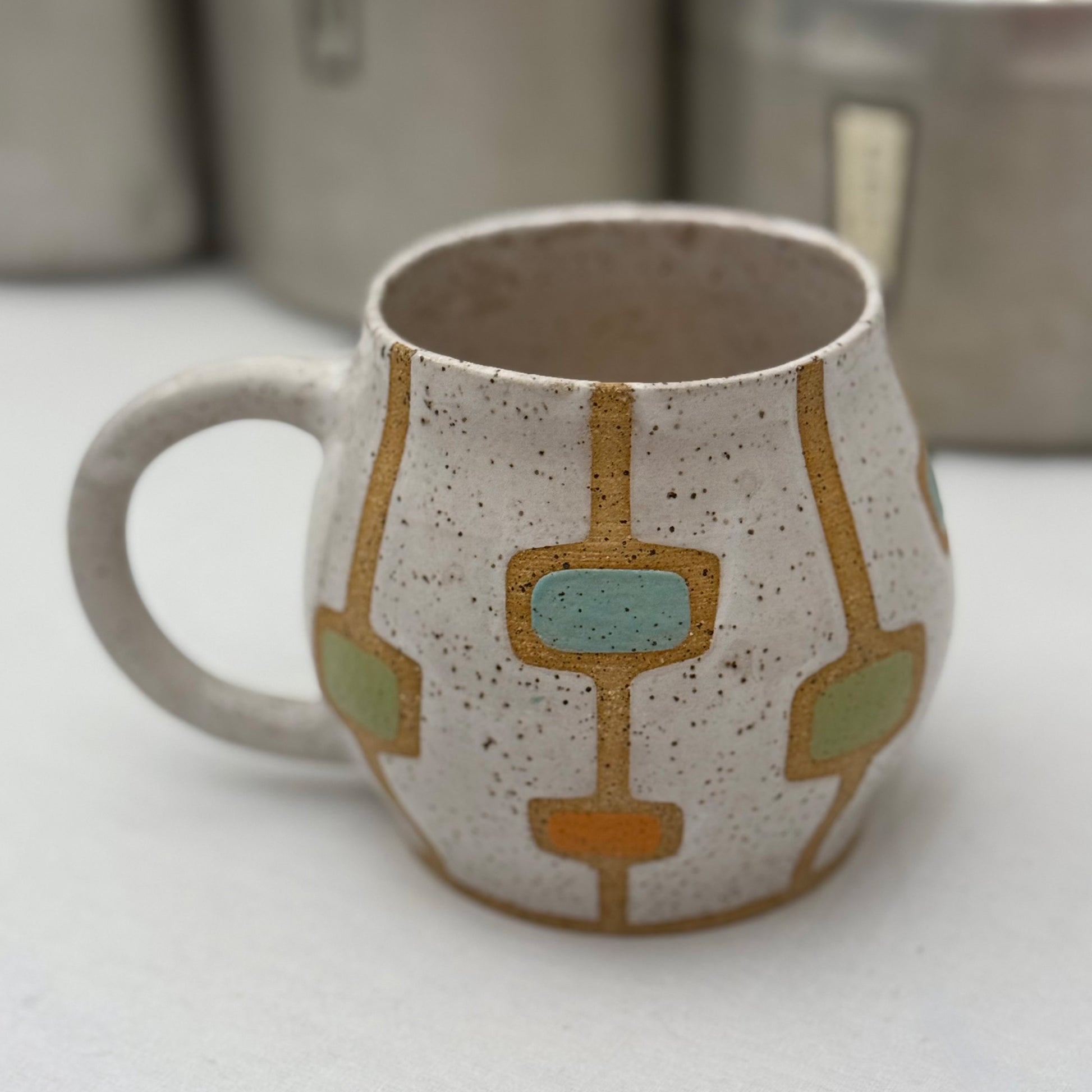 Ceramic mug with geometric patterns on a white surface