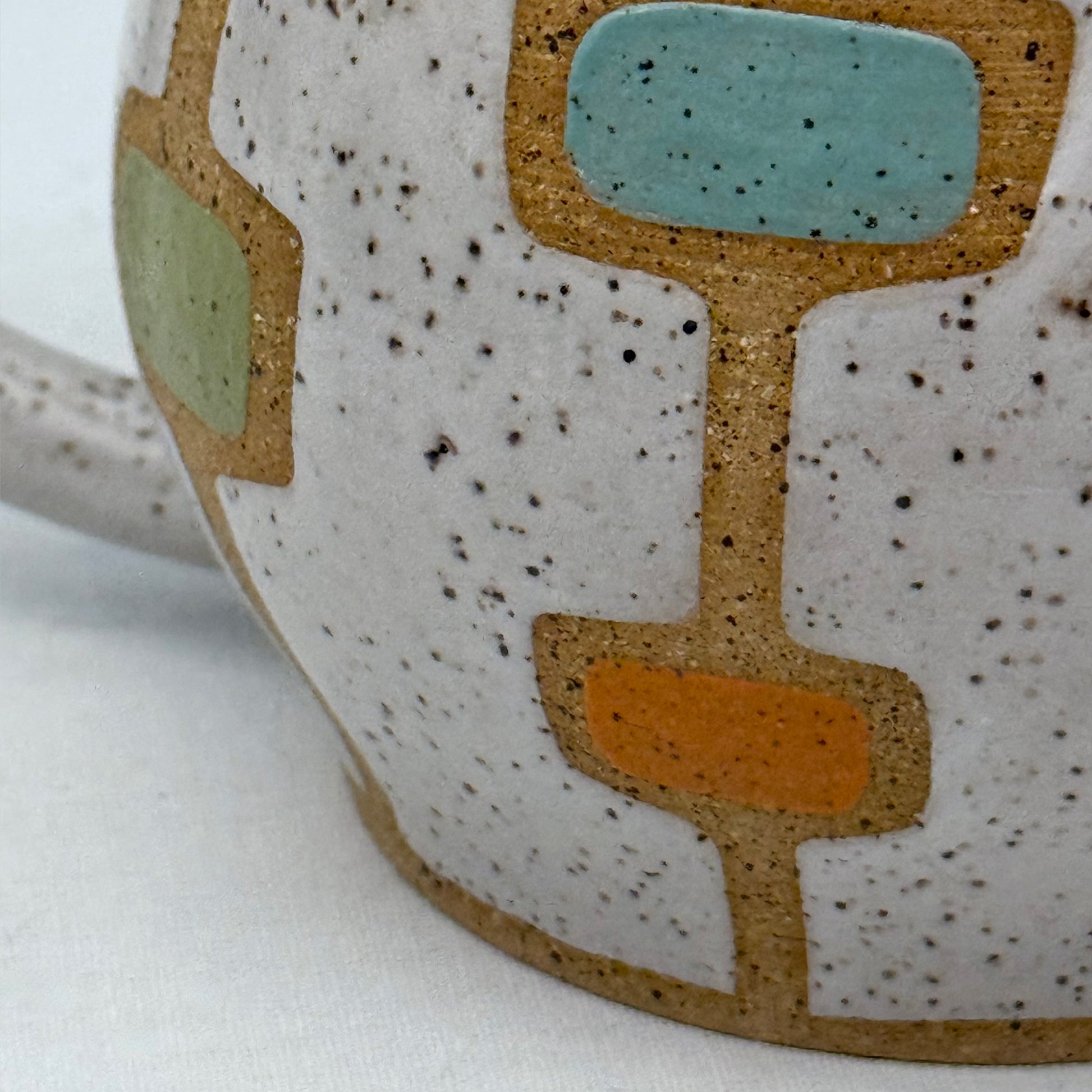 Close-up of a ceramic mug with geometric pattern on a white background