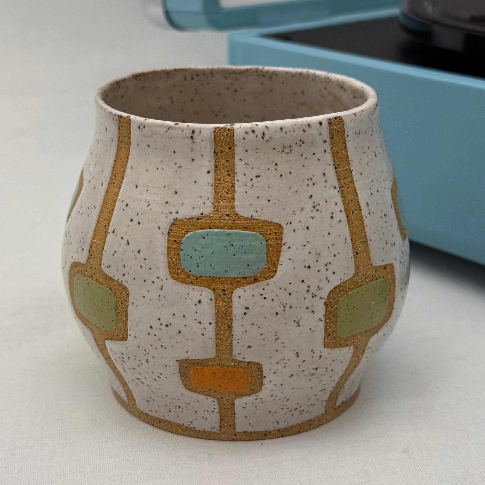 Ceramic cup with geometric pattern on a white surface