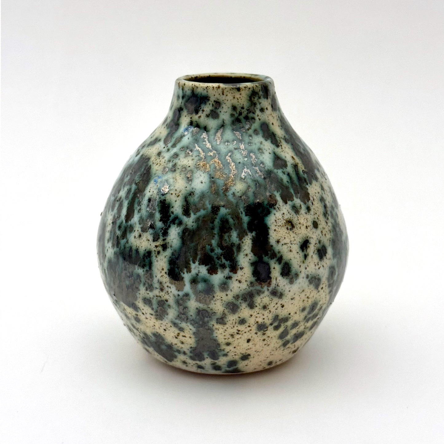Small handmade pottery vase with a rounded shape and narrow opening, finished in a green jasper glaze with varied green tones and irregular speckled patterning across the surface.