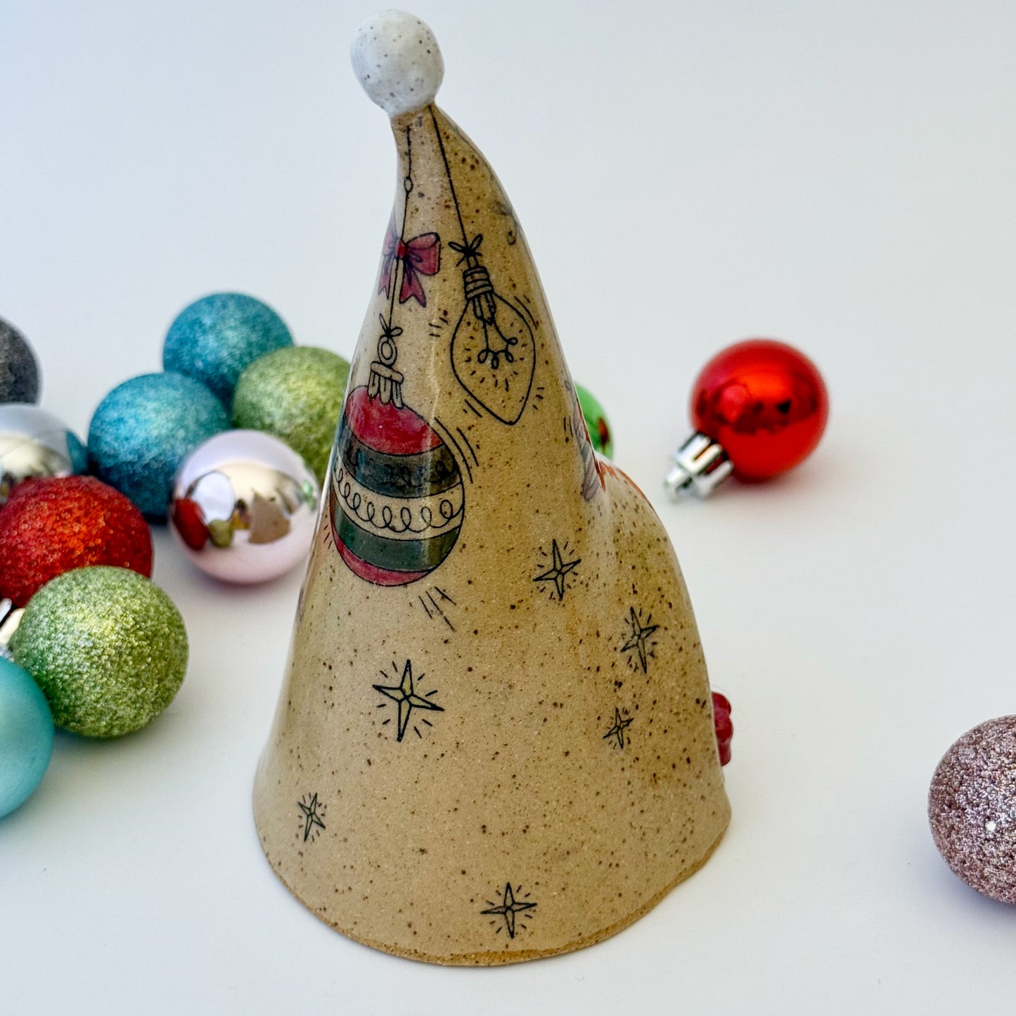 ceramic gnome with braids and red bows with ornaments on a white background 