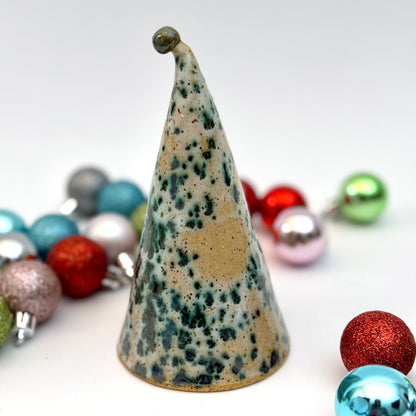 Back view of a decorative gnome figure with a speckled hat surrounded by colorful ornaments on a white background