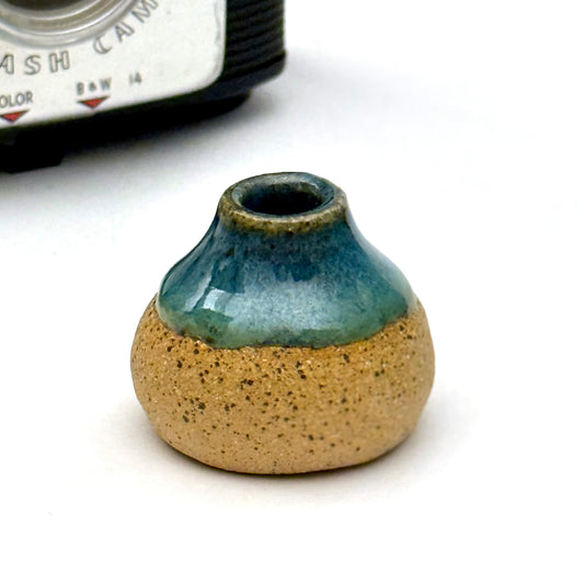 Handmade mini ceramic bud vase with blue glaze over natural stoneware.