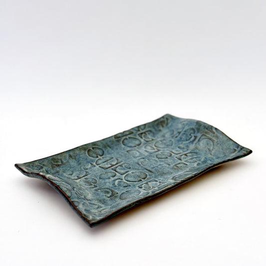 Rectangular hand built stoneware tray with an impressed repeating mid century inspired pattern and layered blue glaze.
