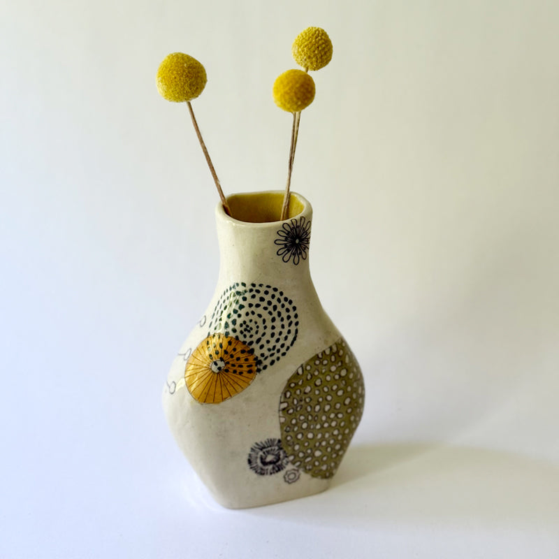 Handbuilt speckled stoneware vase with colorful mid-century-inspired monoprints featuring graphic florals, dotted orbits, and botanical motifs, finished in a glossy clear glaze.
