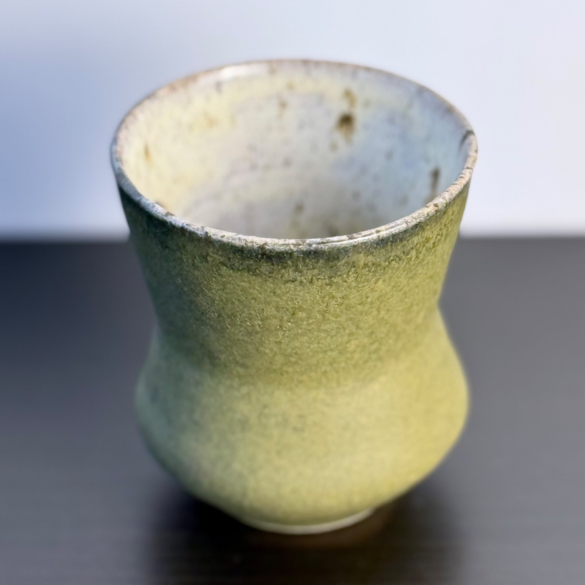 Handmade Olive Cinch Vase with a softly pinched hourglass silhouette, rounded lower body, and matte olive-green glaze with subtle darker variation near the rim and sides.