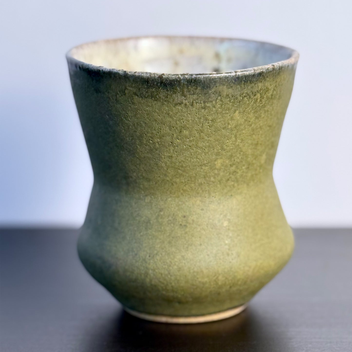 Handmade Olive Cinch Vase with a softly pinched hourglass silhouette, rounded lower body, and matte olive-green glaze with subtle darker variation near the rim and sides.