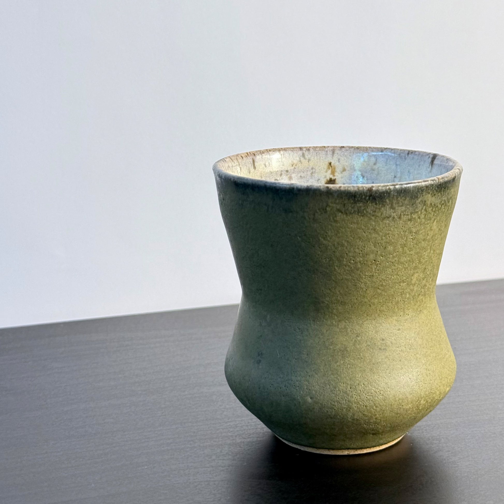 Handmade Olive Cinch Vase with a softly pinched hourglass silhouette, rounded lower body, and matte olive-green glaze with subtle darker variation near the rim and sides.