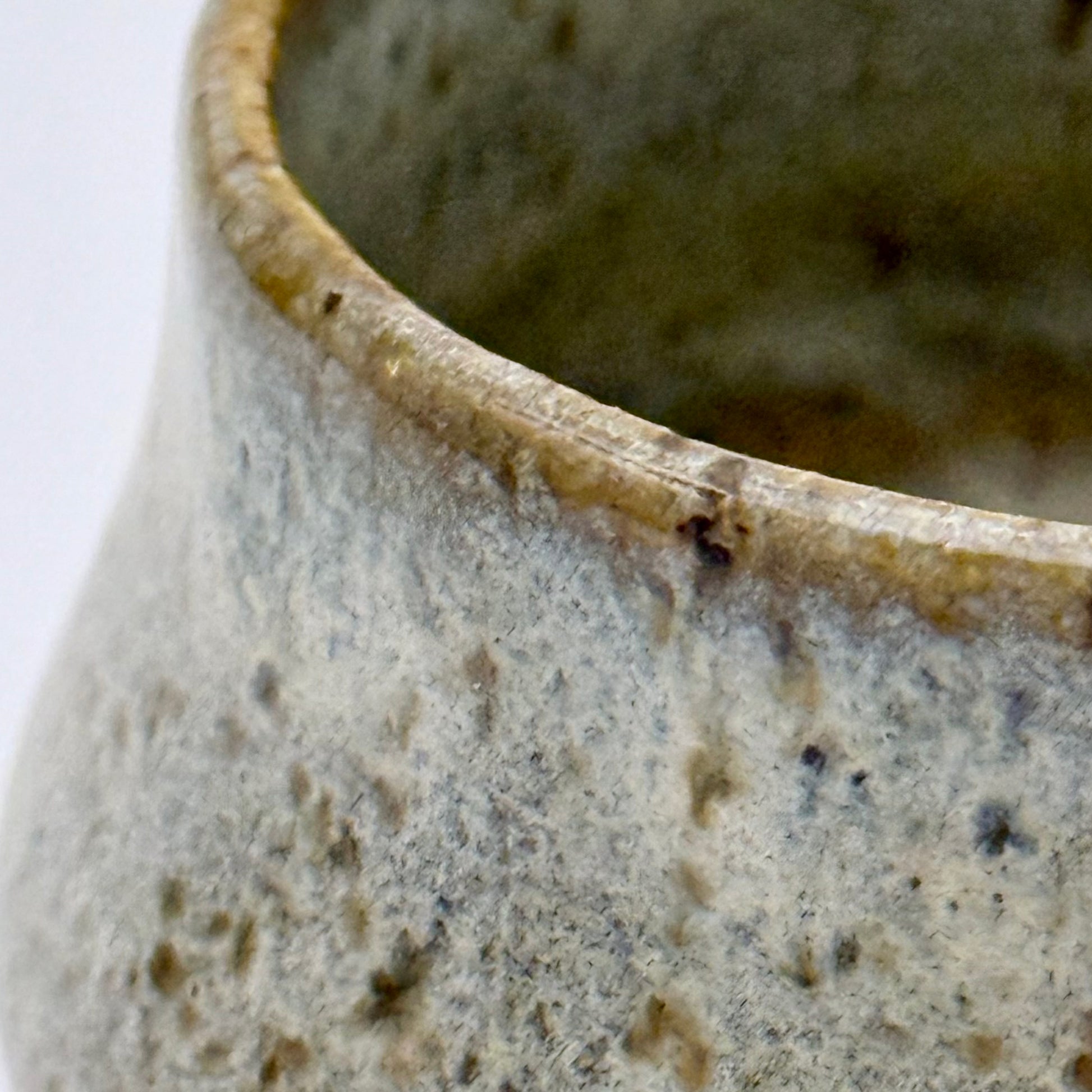 Close-up of a ceramic pot with a textured surface on a white background