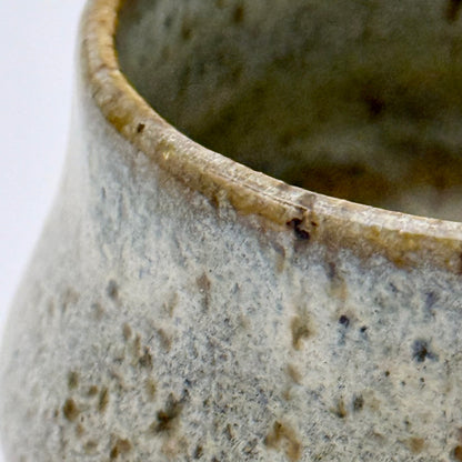Close-up of a ceramic pot with a textured surface on a white background