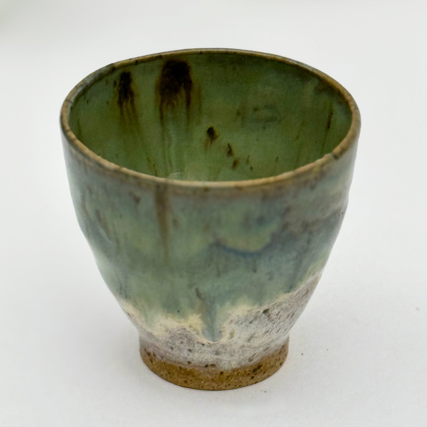Green ceramic pot with brown accents on a white background