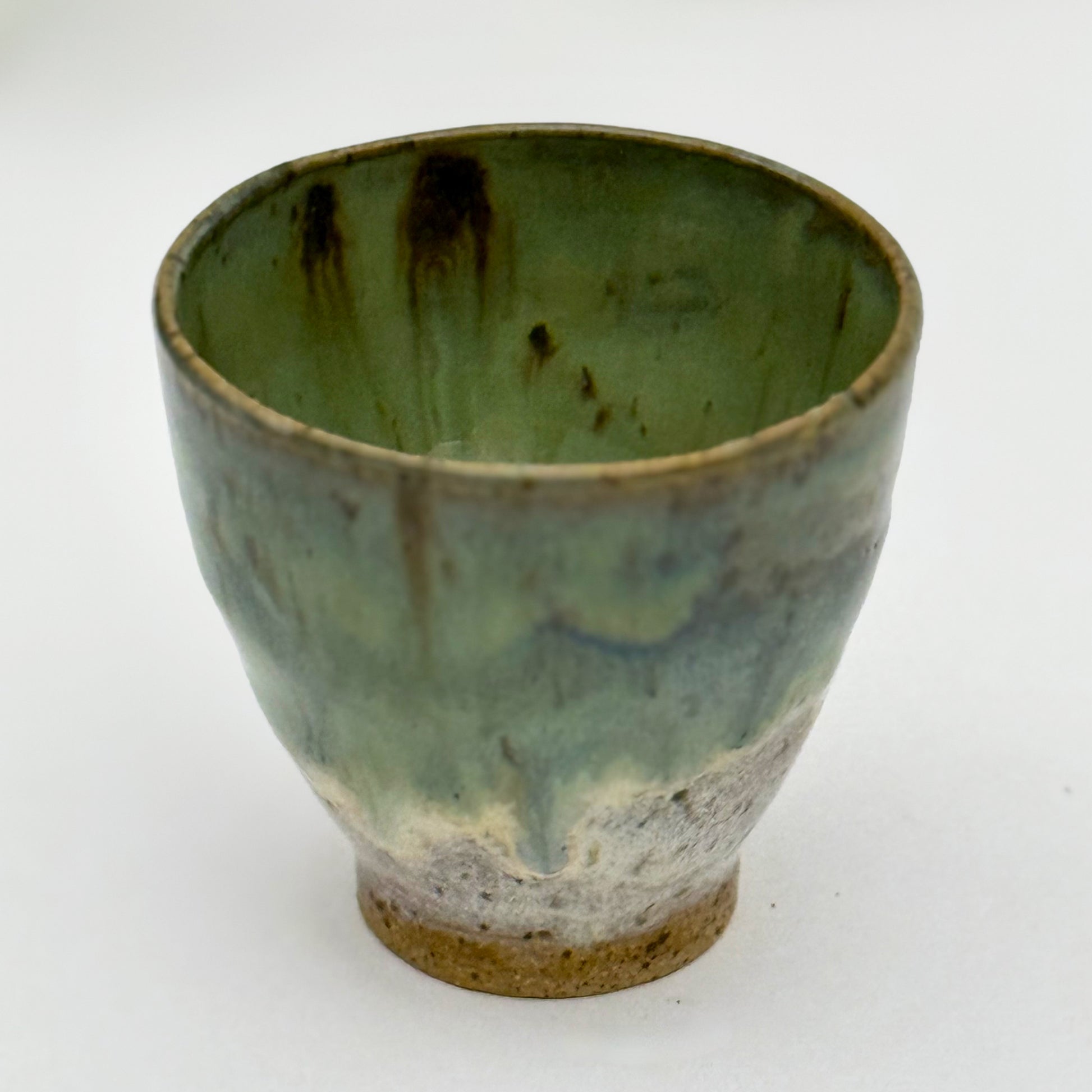 Green ceramic pot with brown accents on a white background