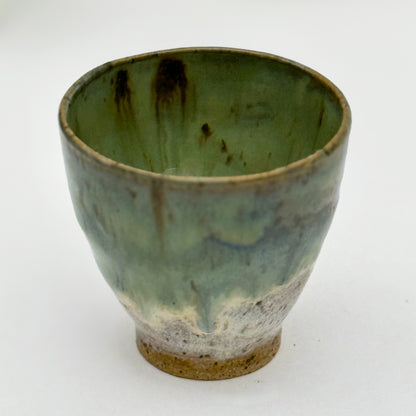 Green ceramic pot with brown accents on a white background