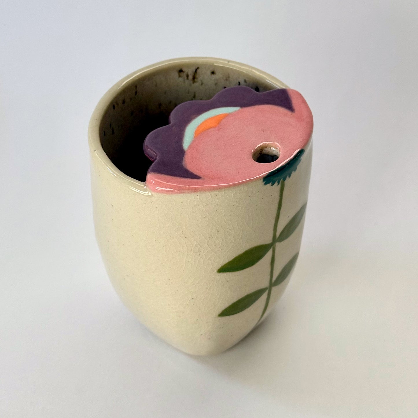 Ceramic to go mug with floral design on a white background