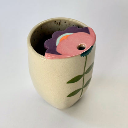 Ceramic to go mug with floral design on a white background