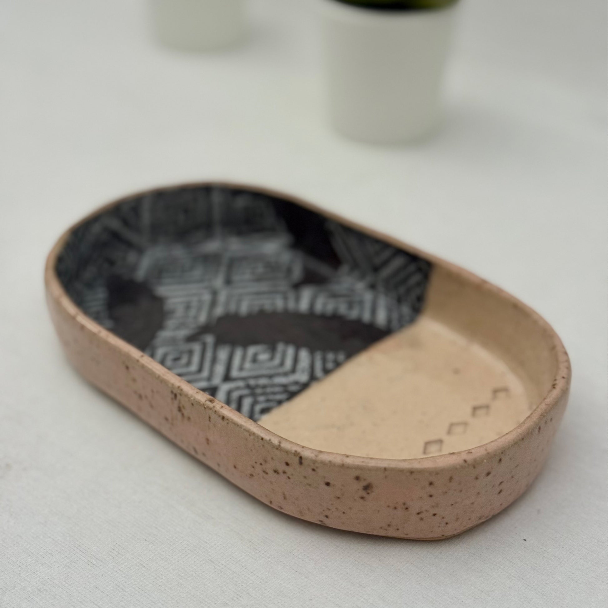 Oval ceramic dish with textured surface on a light background