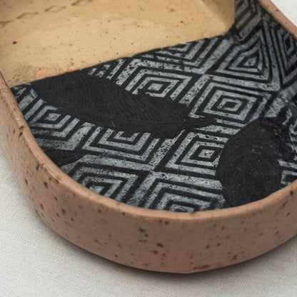 Ceramic dish with geometric pattern on a white background