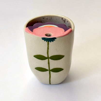 Ceramic to go mug with floral design on a white background