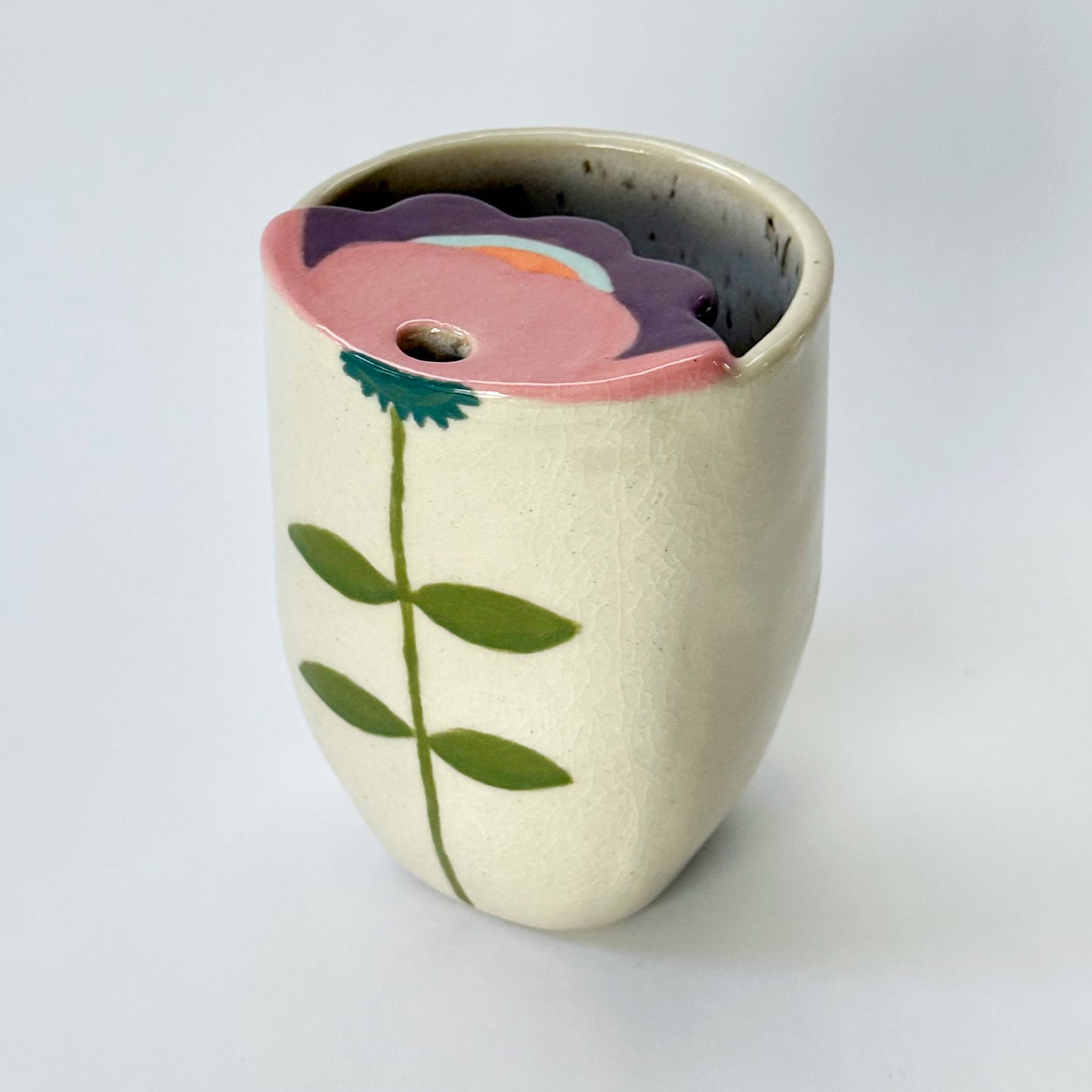 Ceramic to go mug with floral design on a white background