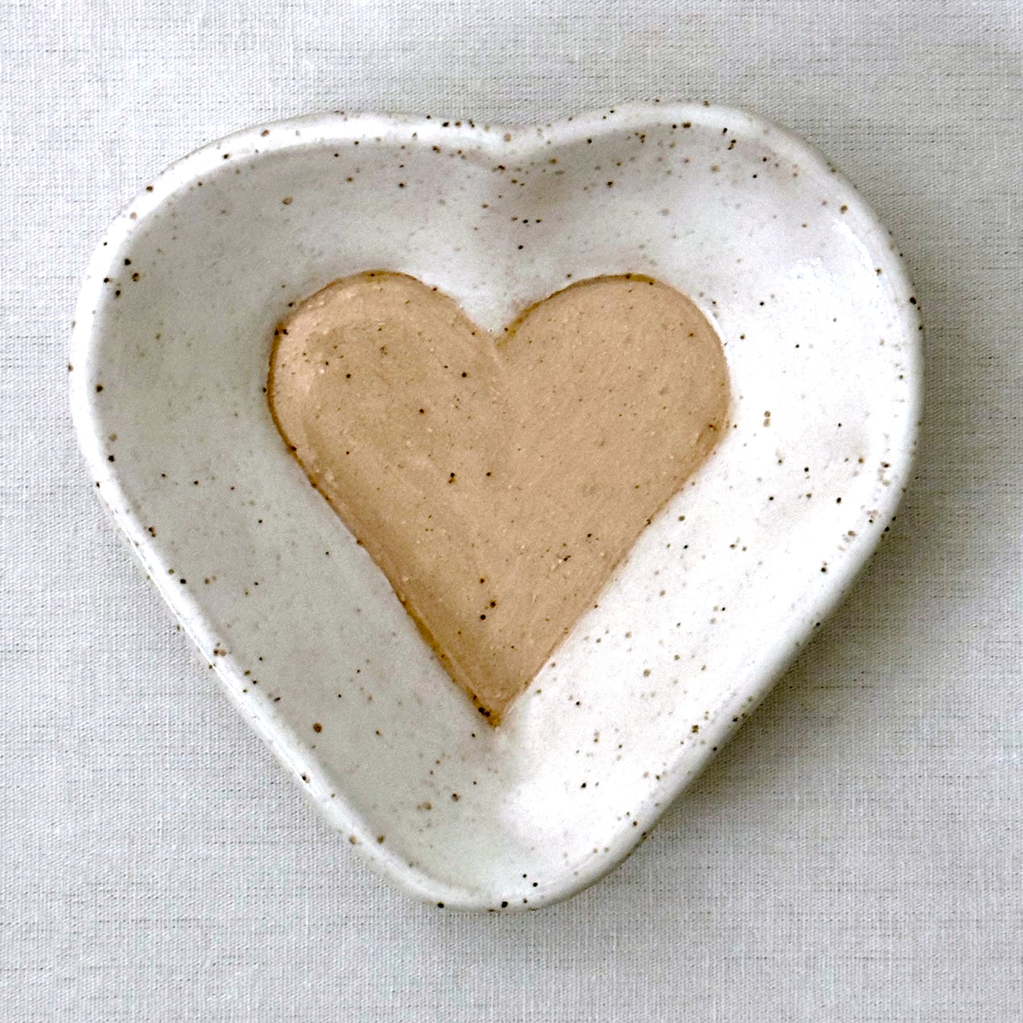 Heart-shaped ceramic dish on a light gray background