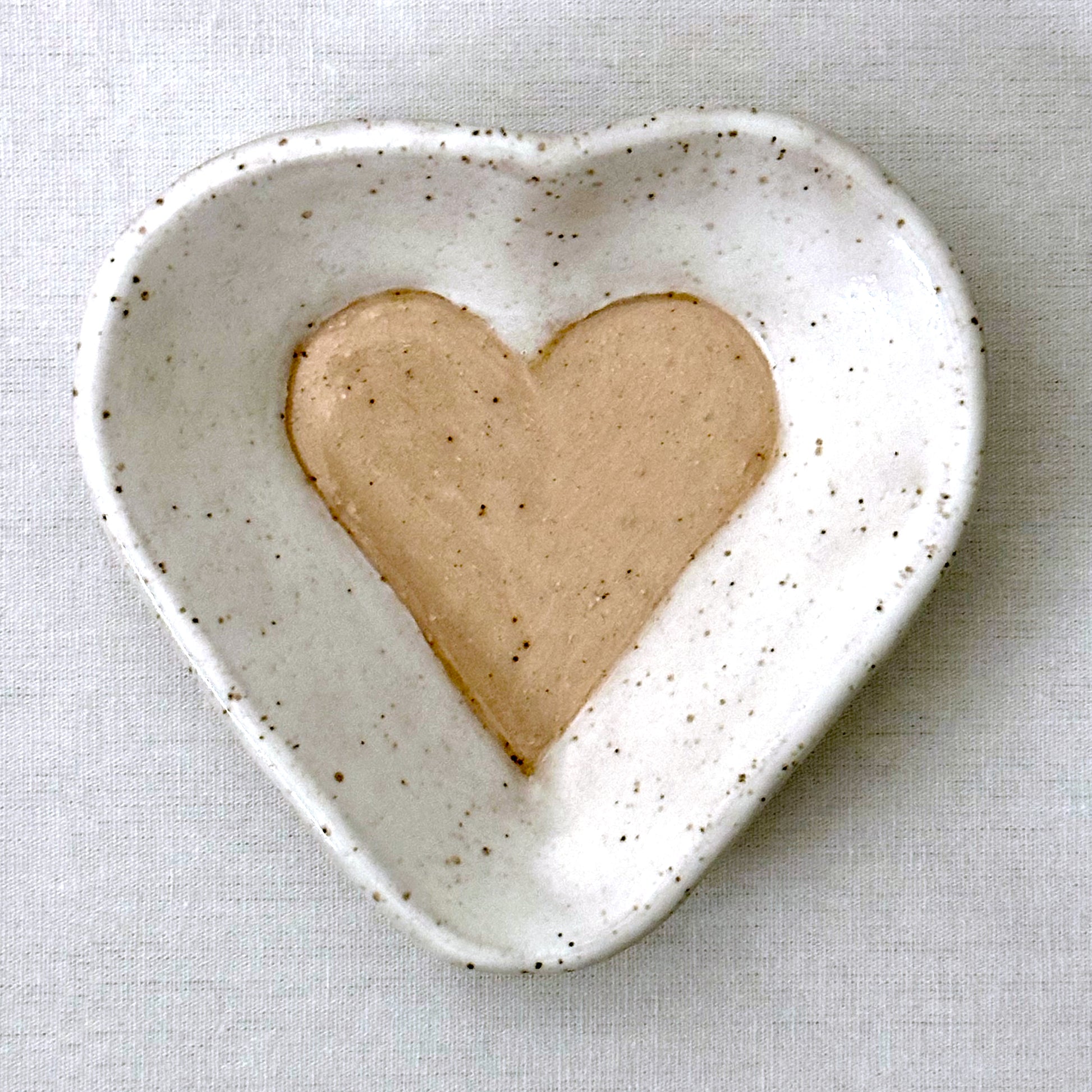 Heart-shaped ceramic dish on a light gray background