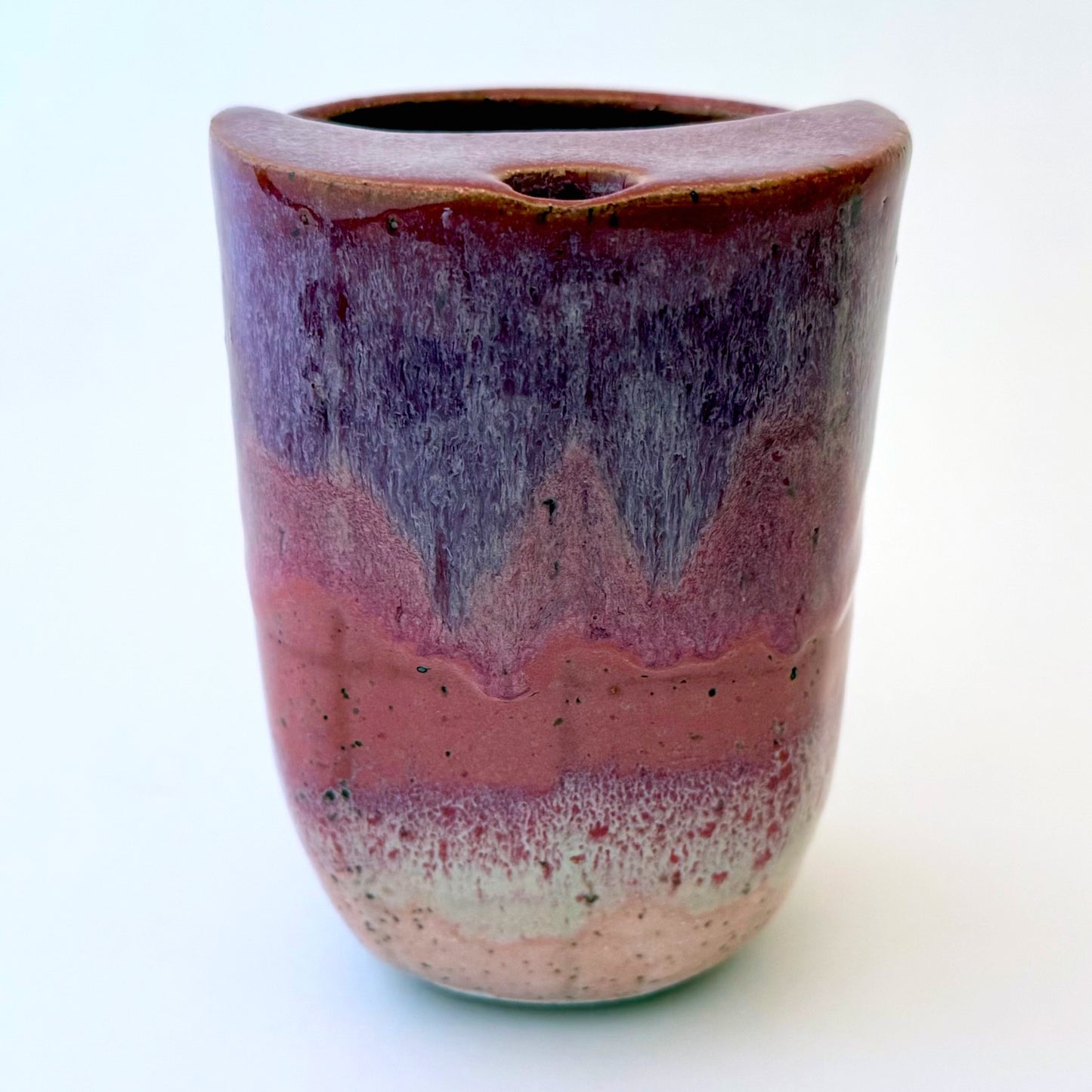 Handmade stoneware to-go mug featuring layered tonal pink glaze from deep berry to soft blush over speckled clay.