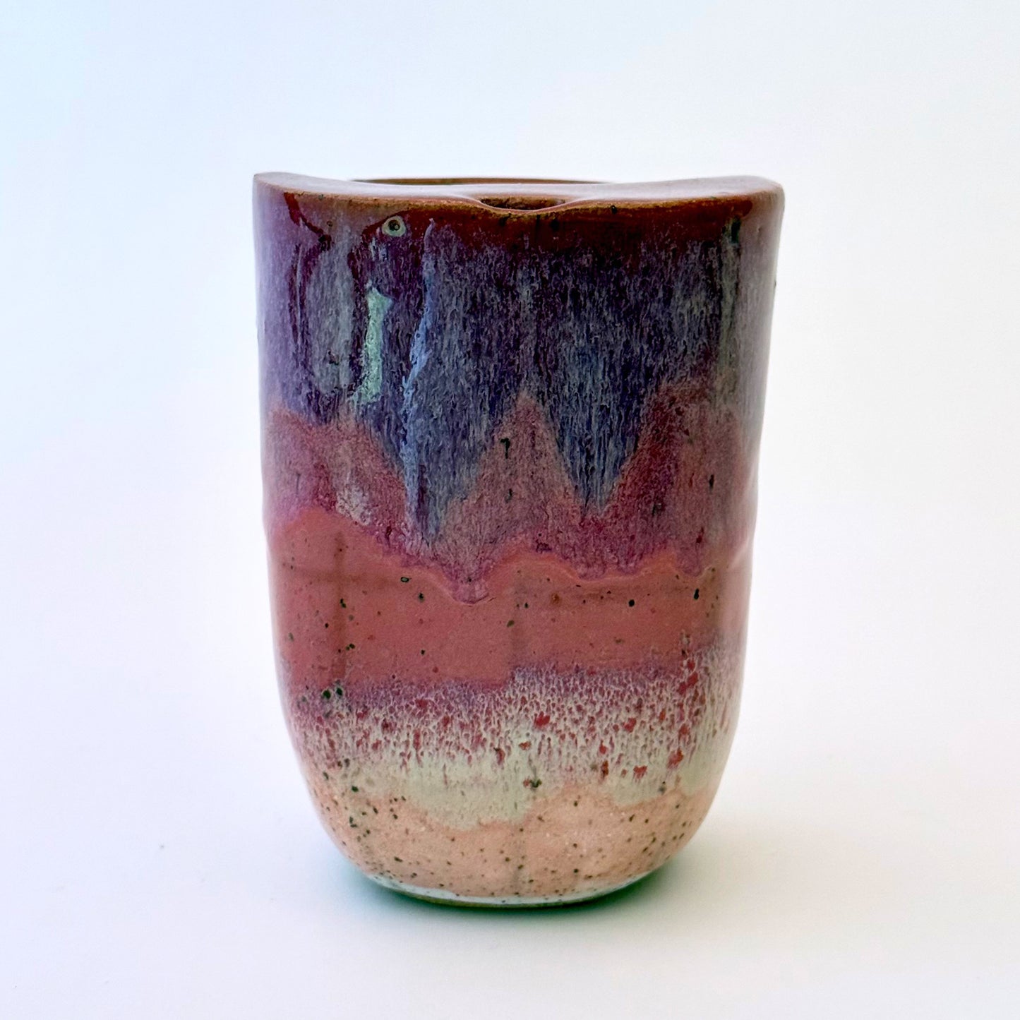 Handmade stoneware to-go mug featuring layered tonal pink glaze from deep berry to soft blush over speckled clay.