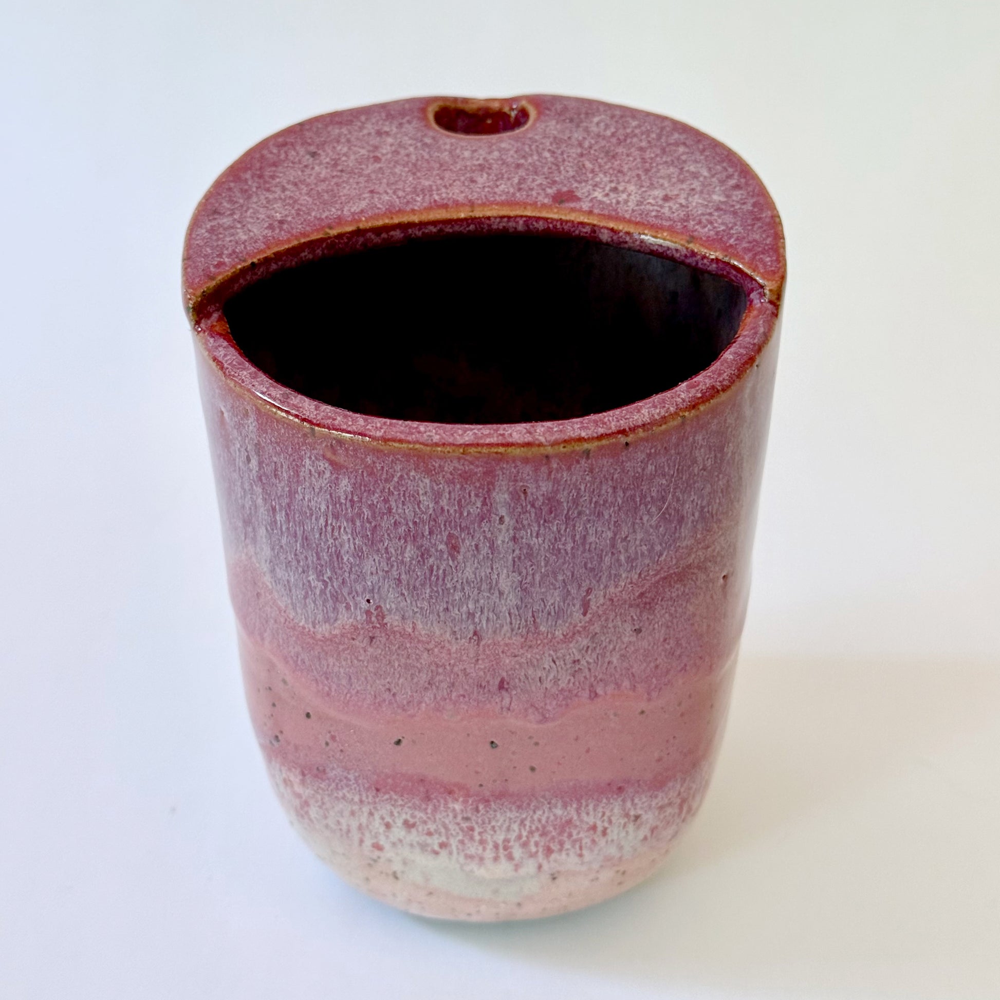 Handmade stoneware to-go mug featuring layered tonal pink glaze from deep berry to soft blush over speckled clay.