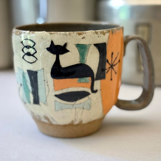 Ceramic mug with a black cat design on an light background