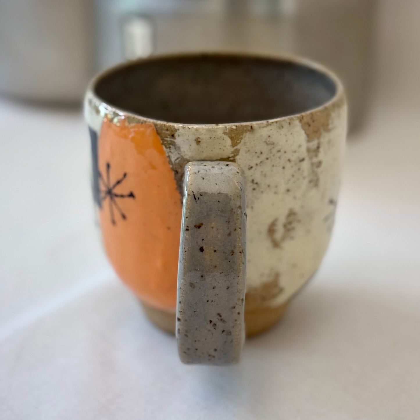 Ceramic mug with a handle on a white surface