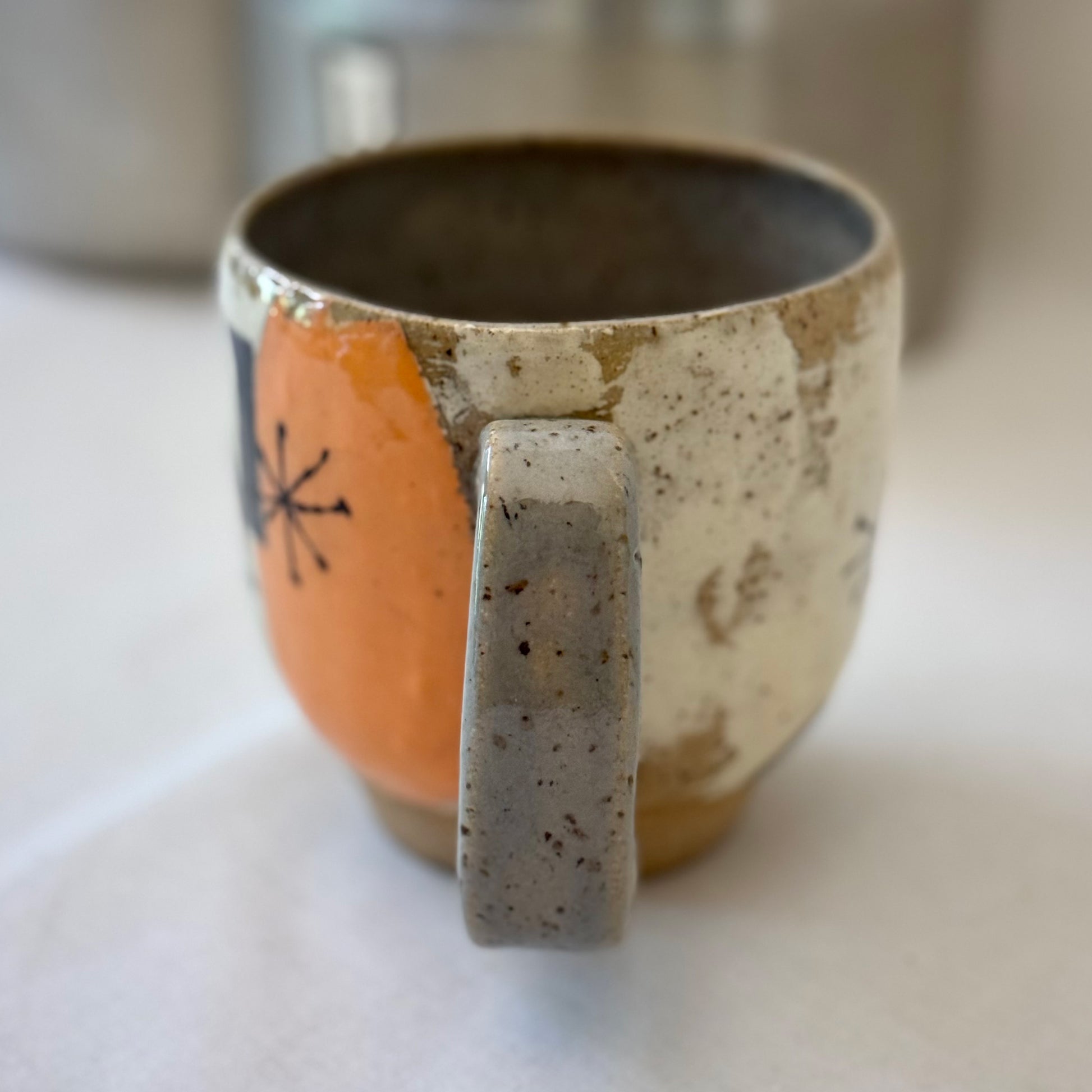 Ceramic mug with a handle on a white surface