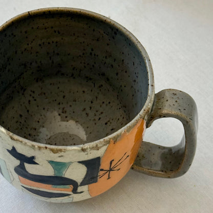 Ceramic mug with mid century design featuring a cat on a white surface