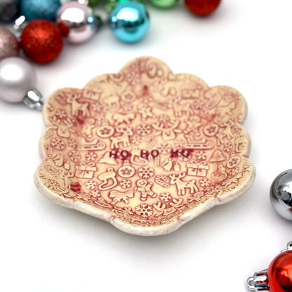 Decorative ceramic plate with Christmas-themed design and ornaments on a white background