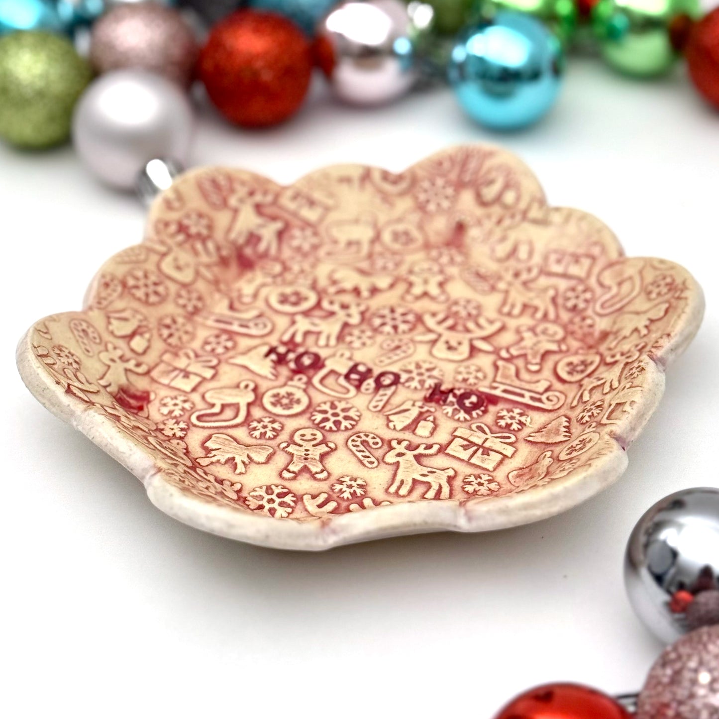 Decorative ceramic plate with Christmas-themed patterns on a white background with festive ornaments.
