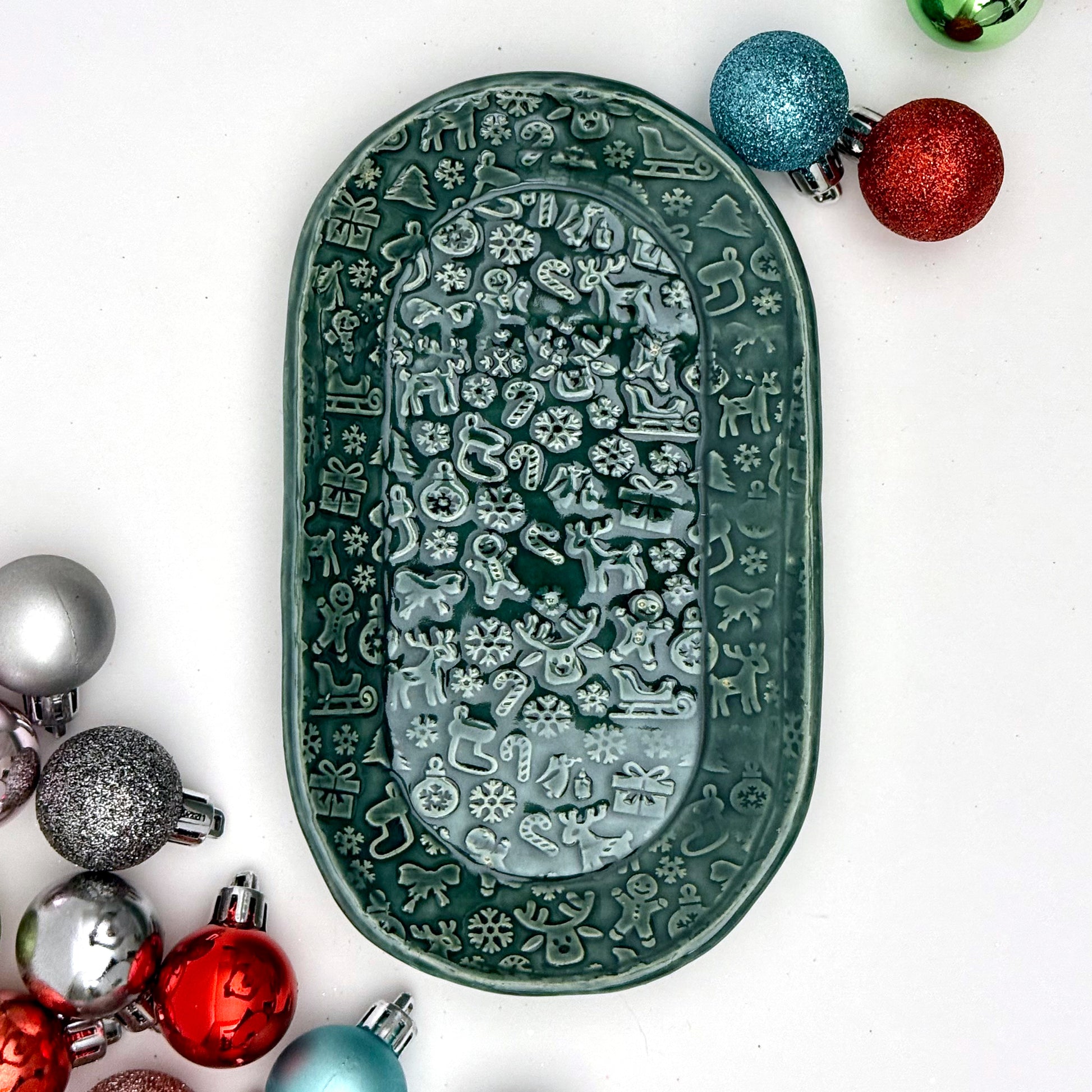 Decorative green plate with holiday patterns on a white background with colorful ornaments.