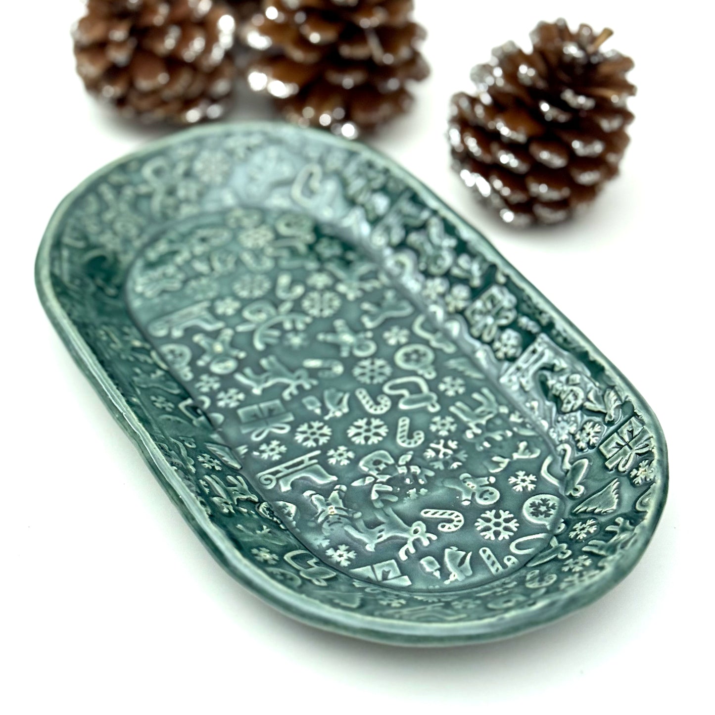 Decorative green plate with holiday patterns on a white background with colorful ornaments.