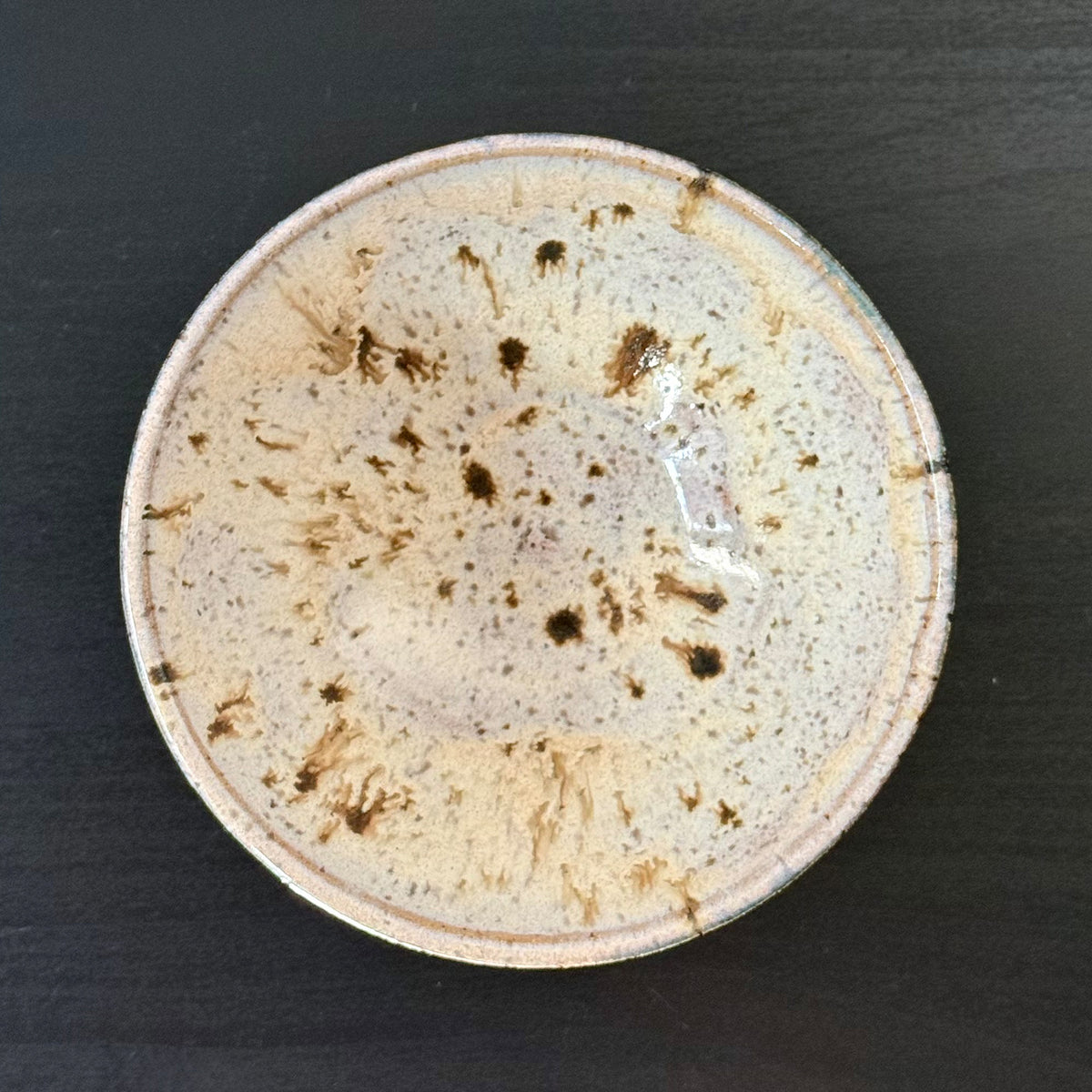 interior view of Handmade ceramic bowl with a saturated teal exterior and a creamy speckled interior, finished with a wide rounded profile and glossy glaze.